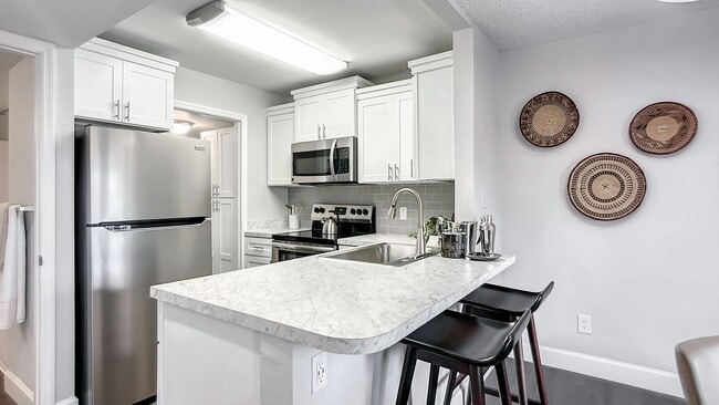 Mejore su experiencia culinaria en nuestras cocinas gourmet renovadas con impresionantes encimeras de mármol blanco y una barra de desayuno. - River Reach