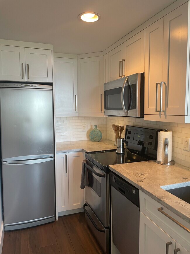 Fully equipped kitchen with dishwasher, dishes and pots and pans