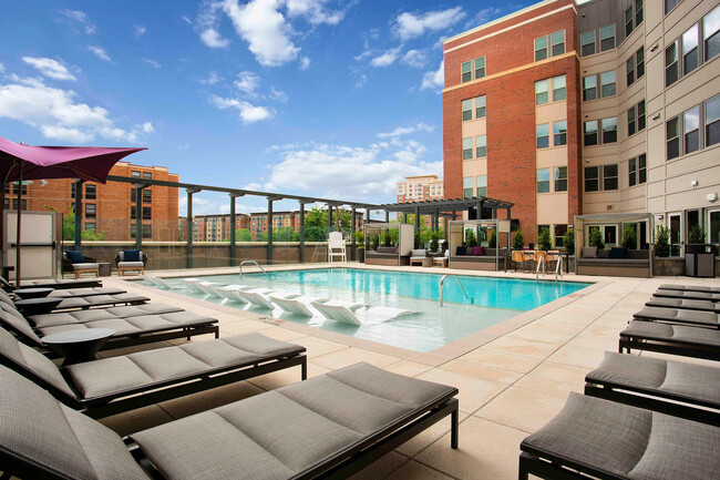 Relax by the sparkling pool with luxurious in-water loungers, shaded cabanas, and skyline views. - The Alloy Rental