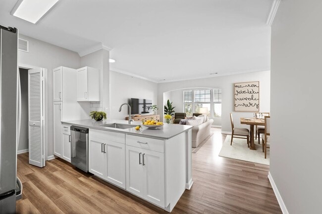 Open kitchen with peninsula seating, white cabinetry, and connected living and dining spaces that support effortless flow throughout the home.