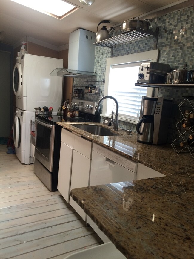 Kitchen open plan w deep SS sink and pull-down faucet. Granite counters.