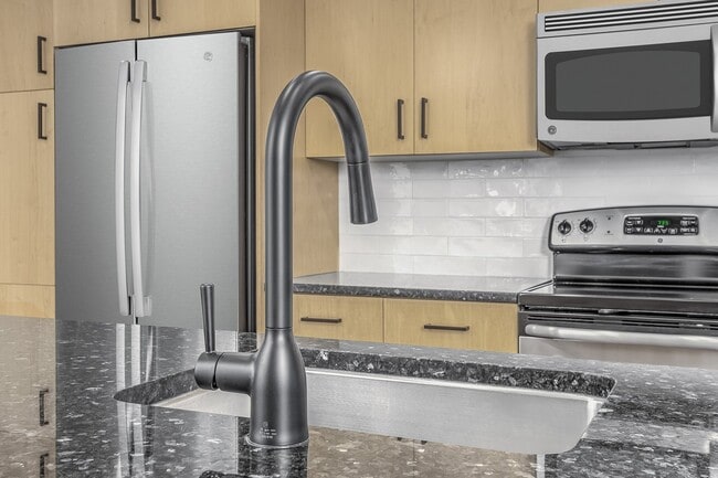 Beautifully renovated kitchens feature modern white subway tile backsplash and sleek matte black fixtures