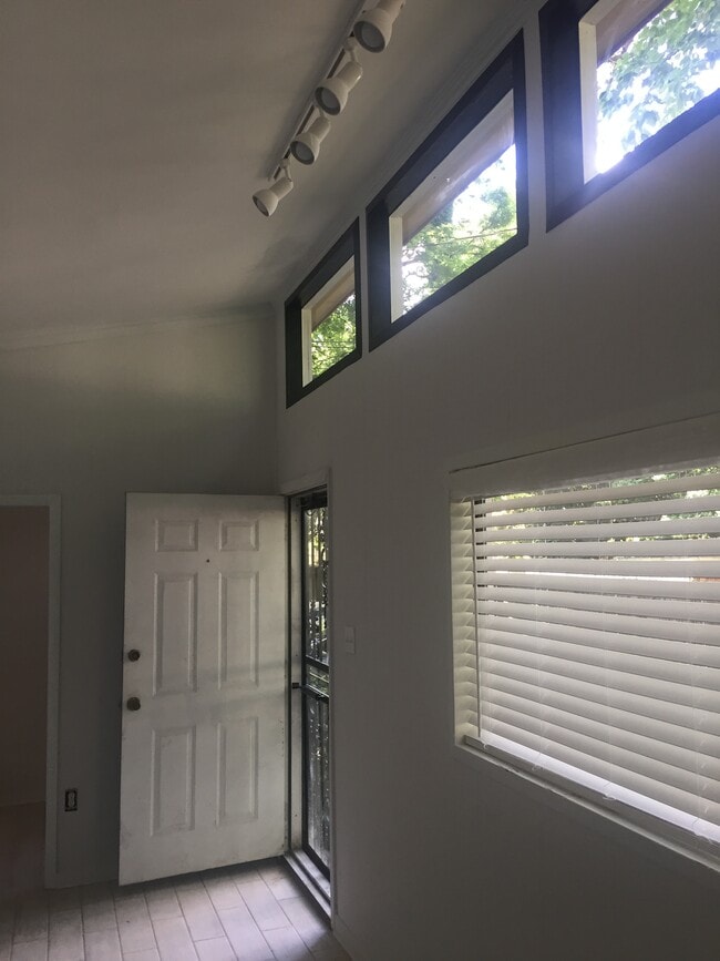 Black-trimmed sky windows, track lighting, and 2" faux wood blinds. Front door to yard - 1742 N Parkway Unit Rear
