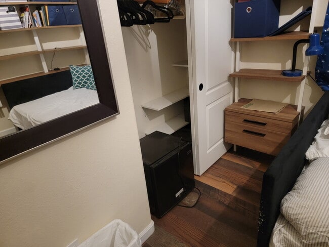 Closet w/ built in shelves for shoes, etc., nightstand w/ open shelves