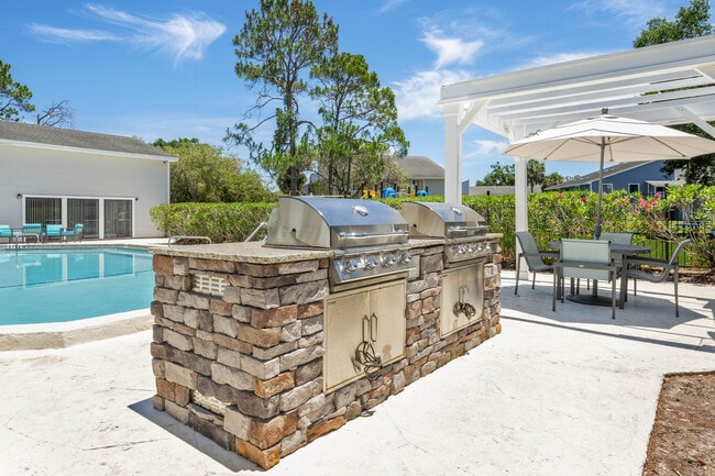 Un espacio exterior acogedor que cuenta con una lujosa zona de piscina con dos elegantes parrillas de acero inoxidable, una pérgola con estilo y un cómodo conjunto de muebles de patio, perfecto para recibir invitados. - Vista North