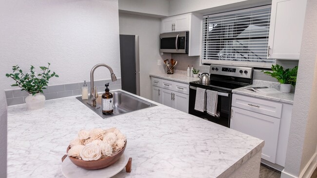 Our modern kitchens boast a marble-style breakfast bar, providing the ideal space for both cooking and entertaining in style. - POSTE Winter Park