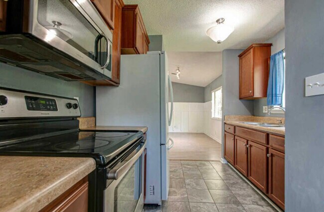 Kitchen with upgraded appliances and tile floor. - 102 E St
