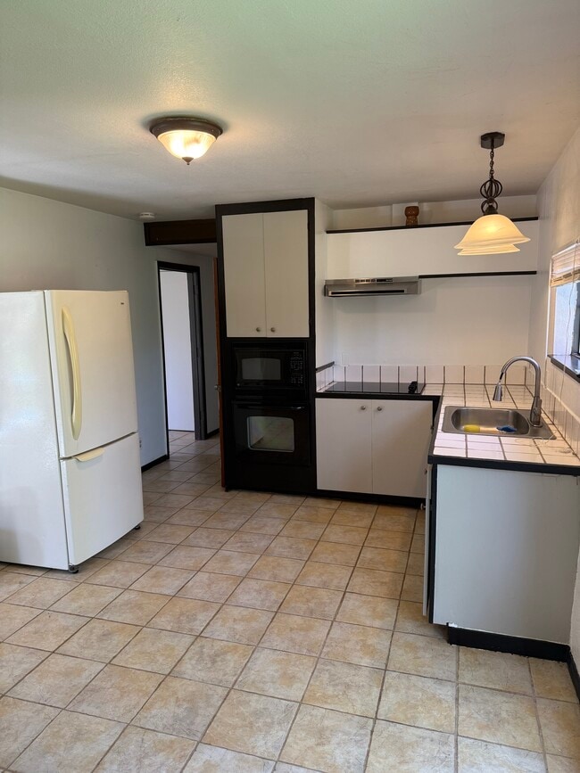 Vista de la cocina hacia el pasillo que conduce al baño y la entrada trasera. - 3333 Hamblen Ct Unidad Lower  Barn