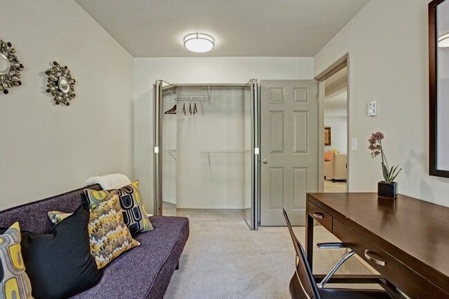 Un dormitorio utilizado como oficina en casa con un sofá cama, un escritorio y una silla, estanterías y una ventana grande. - Windsong