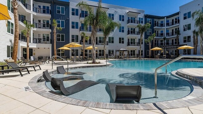 Welcome to Eastborough Apartments, where modern design meets resort-style living. Enjoy our stunning pool, complete with lounge chairs and vibrant landscaping. Elevate your lifestyle today—schedule a tour to find your new home! - Eastborough Apartments
