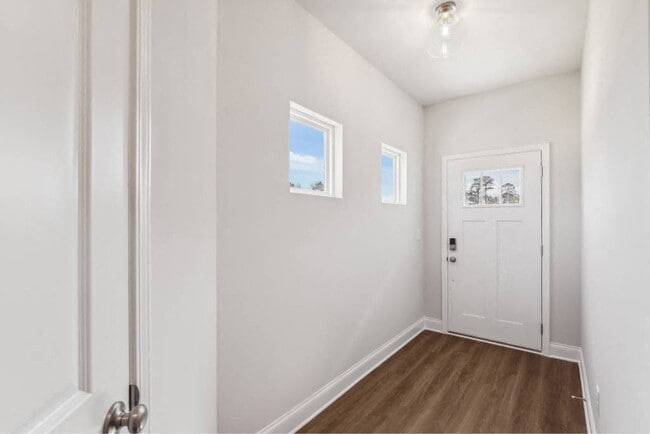 The entrance to the Carlisle home featuring rich hardwood-style flooring and crisp white walls. - Poplar Row