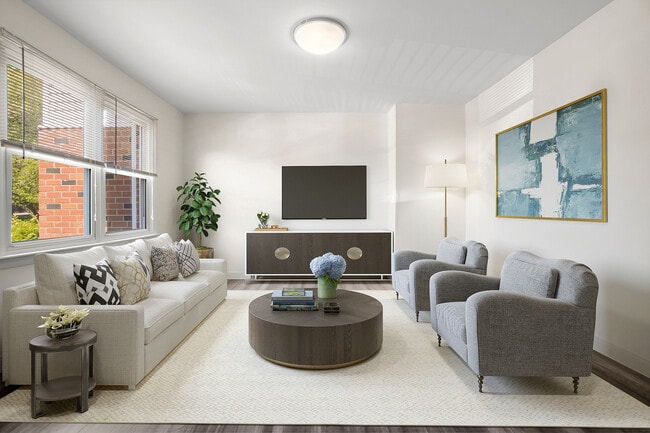 Bright and inviting living room featuring a modern aesthetic with cozy seating, elegant decor, and ample natural light through large windows.