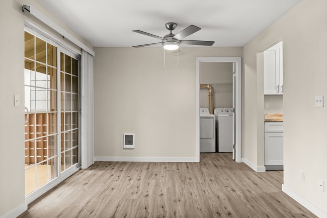 Dining space with modern ceiling fan and in-home laundry access.