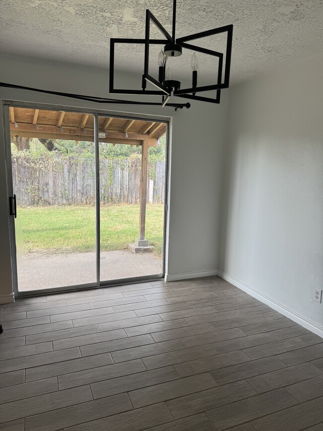 Sliding glass doors opening directly onto a patio, bringing in ample natural sunlight. - 10038 Spring Place Dr
