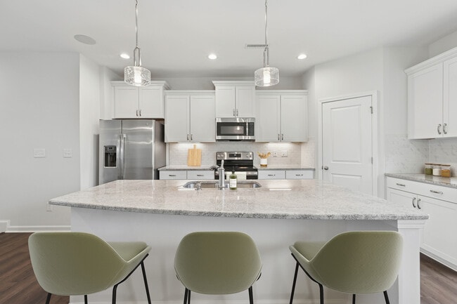 Upgrade Package kitchen with white cabinetry, designer tile backsplash and undercabinet lighting, and granite countertops