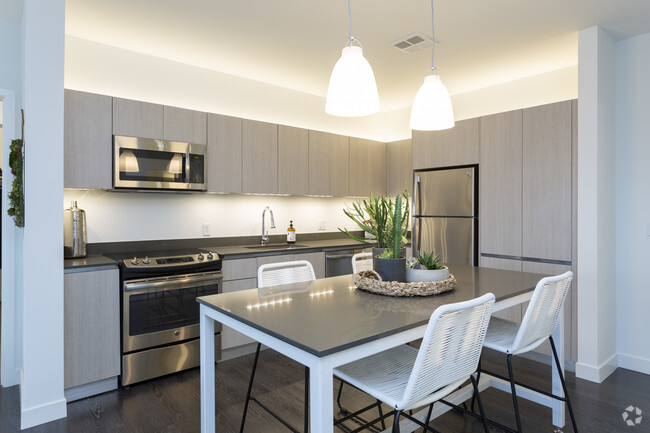 Modern, sleek kitchens feature above and under-cabinet lighting, stainless steel appliances, large s - Woodside Village North Apartments