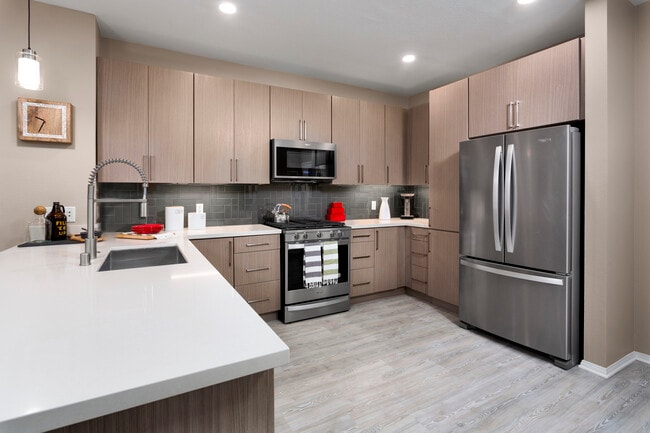 Design Scheme II Kitchen with quartz countertops, stainless steel appliances, and hard surface plank flooring