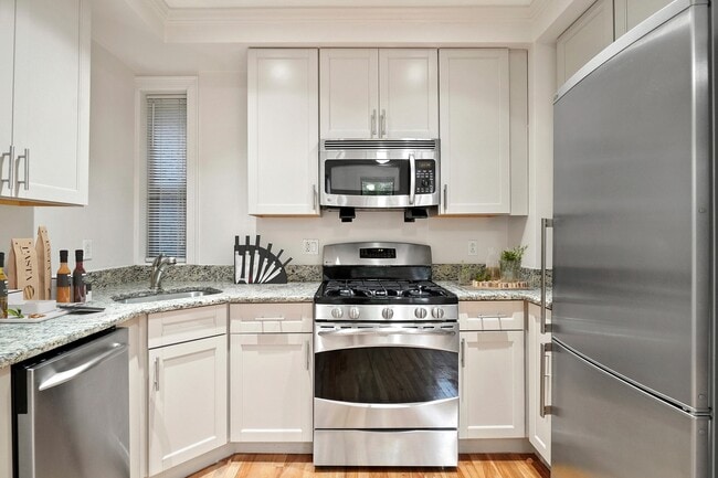 Modern kitchen with sleek stainless steel appliances, granite countertops, and elegant cabinetry.