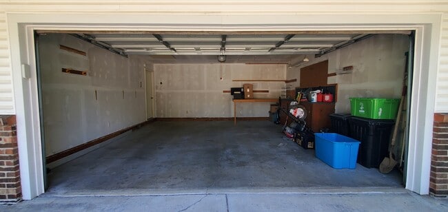 2 car garage with storage shelves/cabinets and work table. - 313 Britanna Dr