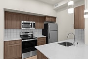 Modern in-home kitchen with stainless steel appliances and stylish wood cabinetry.