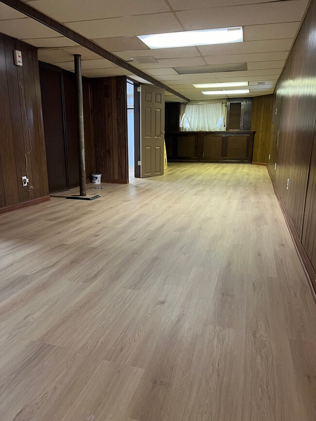 Sala de estar con nuevos pisos por todo el basement. - 5445 N Monitor Ave Unit 1