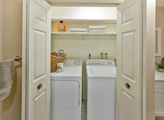 Spacious laundry closet with full-size appliances and built-in shelving at Haynes Run Apartments in Medford, NJ. - Haynes Run