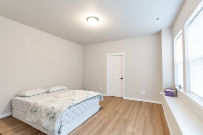 Amplio dormitorio principal con baño adjunto y ventanal. - 7471 SE Kinnaman St