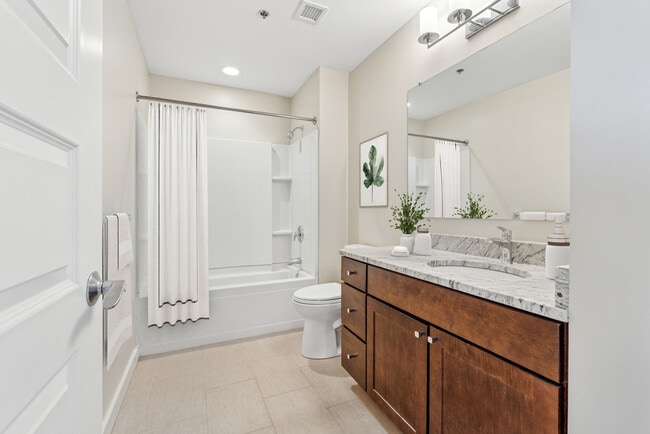 Spacious apartment bathroom with double-sink vanity and upscale finishes