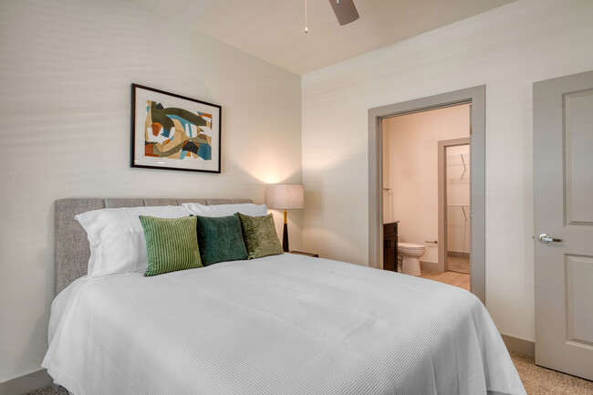 Spacious Oakwood Trails Apartments - A 62+ Affordable Community in Spring, TX bedroom with neutral tones, large windows, and plush carpeting for comfort and relaxation.