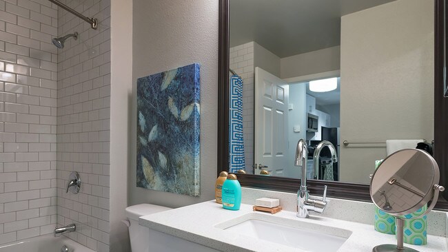 Framed vanities, floor to ceiling tile surround, and granite countertops