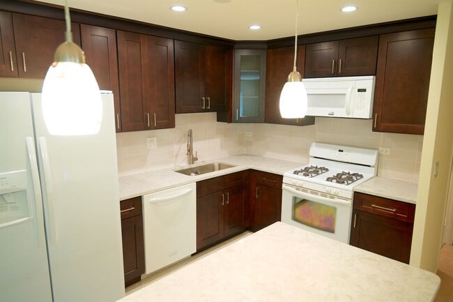 Open Kitchen with isle and pendant lights - 1250 Park Ave W Unit 408