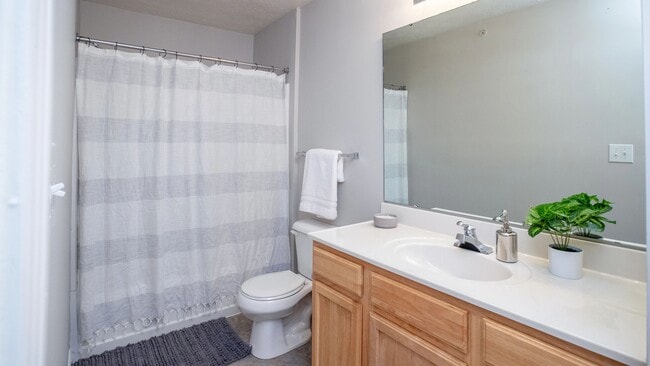 Bathrooms with wood-style flooring, spacious vanities, and oversized mirrors.