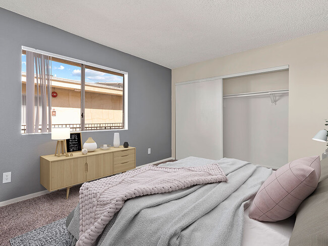 Carpeted bedroom with accent wall and large natural light window. - Riverbridge Apartments