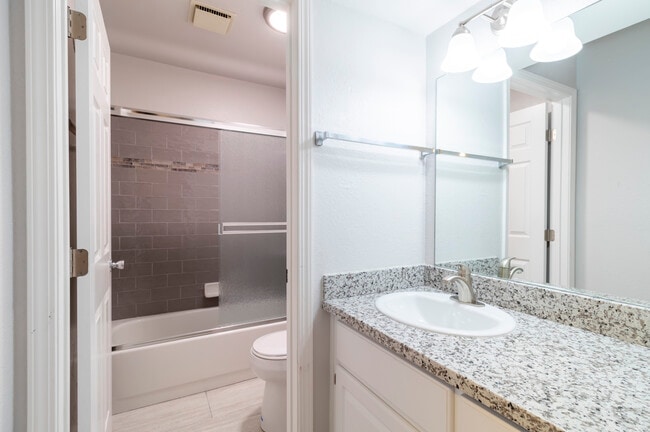 Baño para residentes en tonos gris - Eastwood Apartments