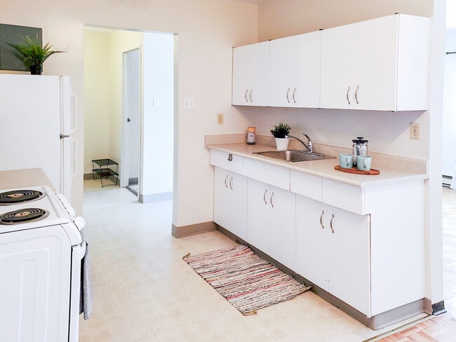 Experience the convenience of a well-equipped kitchen with plenty of storage and counter space at 1025 Munroe Apartments. - 1025 Munroe Avenue