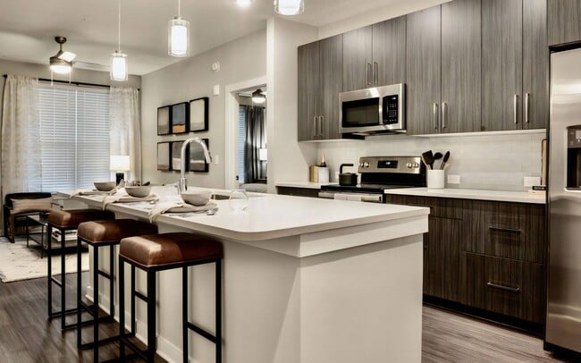 Kitchen with Island Seating, Dining Area, and Stainless Steel Appliances