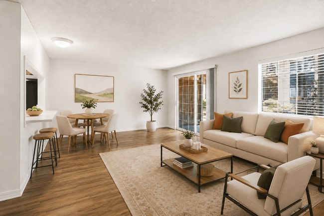 A bright, inviting living and dining space with modern styling and convenient patio access at Chambers Pointe Apartments.