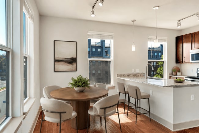 A modern kitchen with a dining table and chairs. - ICON at Dulles