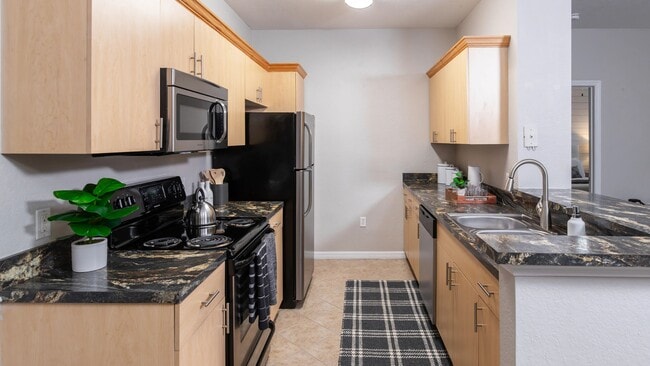 Experience the perfect blend of style and function in this modern galley kitchen, featuring sleek black appliances, elegant countertops, and ample storage.