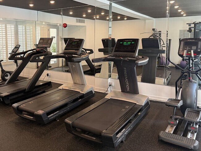 Fitness Center With Treadmills, Free Weights, and Bikes.