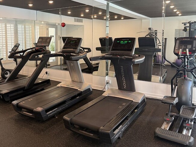 Gimnasio con cintas de correr, pesas libres y bicicletas estáticas. - Clarington Court