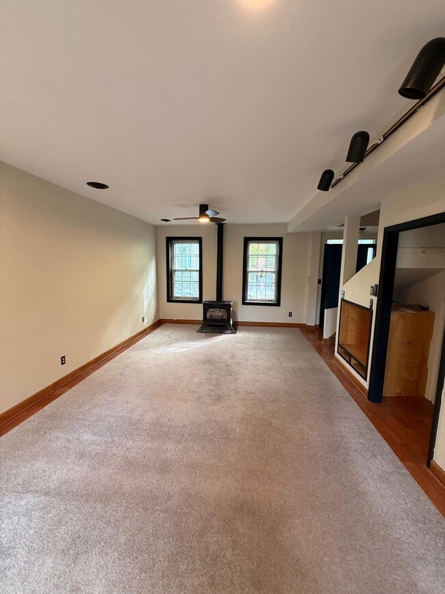 Windows face Hudson, Gas heater for cozy warmth and ceiling fan above - 327 Hudson Ave Unit Apartment #1