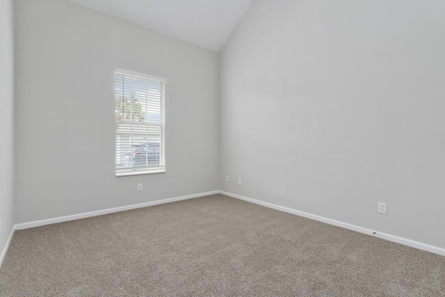 Orleans Metairie Deluxe Renovated downstairs bedroom with vaulted ceiling and plush carpet
