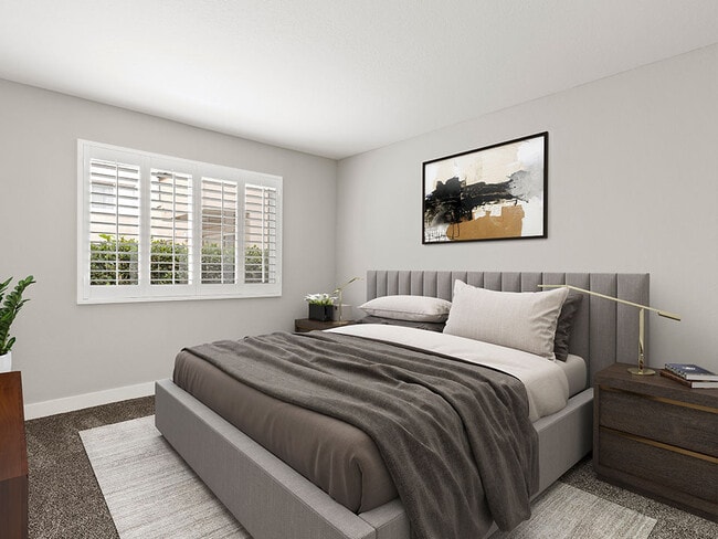 Carpeted bedroom with large natural light windows.