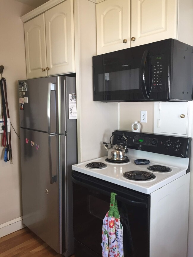 Kitchen with new fridge and microwave. - 1347 W Highland Pkwy House