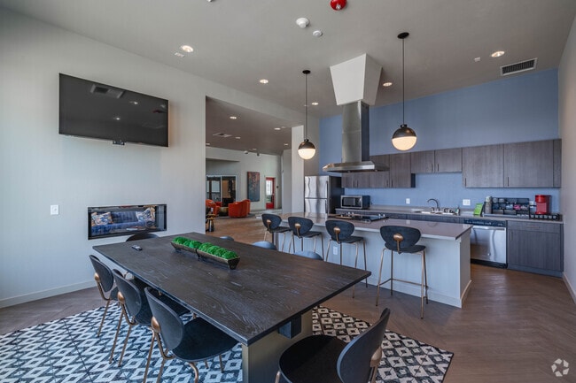 Salón social peculiar con salón comunitario, cocina, chimenea y espacios de trabajo comunes