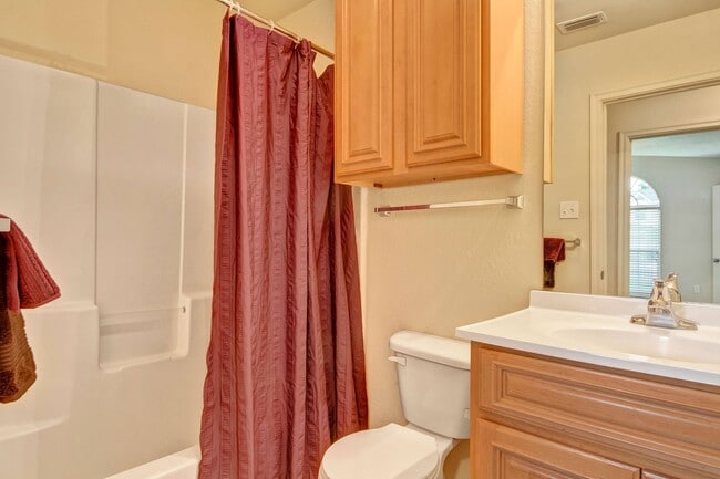 Un baño con combinación de bañera y ducha y armarios de almacenamiento adicionales. - Lexington Court