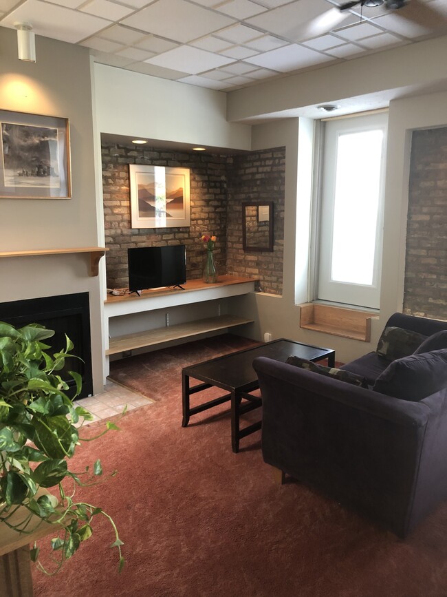 Exposed brick, fireplace, built-in shelving - 3313 N Clark St Apartments Unit 3R