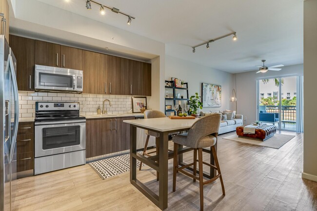 Kitchen and Living Room View with Island and Private Balcony Access