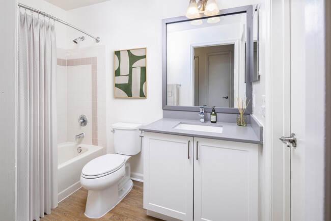 Renovated Package III bath with grey quartz countertops (select homes), white cabinetry, and hard surface flooring - eaves West Windsor